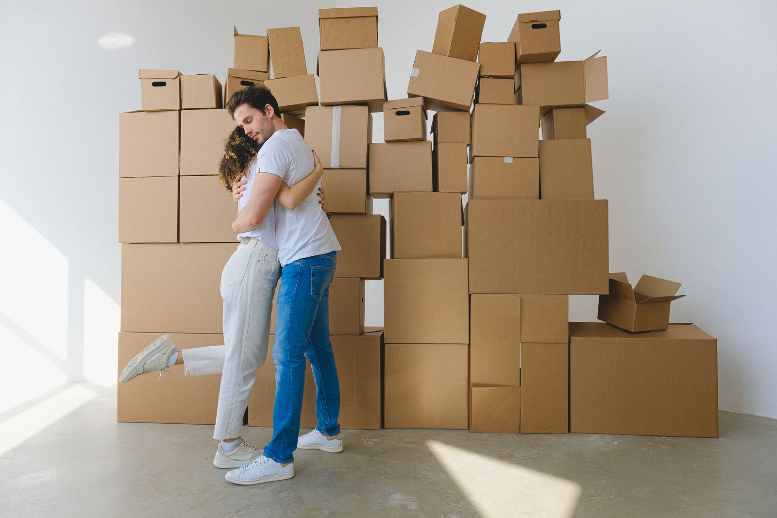 A couple embracing beside boxes during a move
